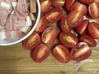 5、土豆丝培根披萨,这时我们可以来准备配料：培根切小块，圣女果对半切开。