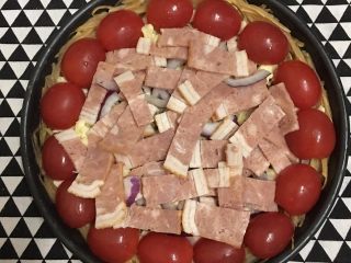 7、土豆丝培根披萨,将圣女果摆放好之后铺上培根。