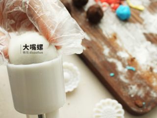 20、Q萌红糖冰皮月丨大嘴螺,包好后的冰皮红豆沙裹一层熟糕粉，放入模具中压紧实，顺着模具压就完成了