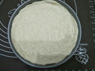 10、培根蔬菜披萨,发酵好的面团加点油放在案板揉一会排气后撠成面皮放入烤盘并用叉子叉出小孔防止烤的时候鼓起。