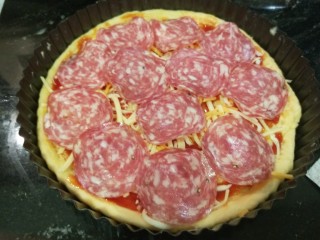 8、新文美食  自制烤箱板披萨,铺上一层肠片。