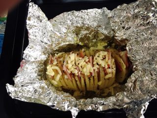 7、芝士培根焗土豆,土豆烤制好后加入培根。撒上盐花、黑胡椒、披萨草。土豆表面铺上多多的芝士碎。再次入烤箱180摄氏度烤制15分钟。