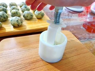 13、又香又酥的黑芝麻杂果干桃酥,用模具压花！模具不用涂油，因为面团本身就是蛮油的了！压的时候要注意力度，太轻则看不见花纹，太重又会把面团压散，我一般都是中间按下去，再用手掌的力四周再轻轻按一下，停留两三秒，再轻轻的提起模具！如果你觉得压的不好，可以再把面团轻轻捏几下，重新再压！压到你满意为止！其实压花压多几次就会有经验的了！