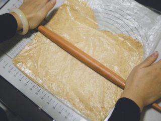 3、五行缺吃之重乳酪蛋糕,将消化饼干用擀面杖杆碎，要完全碾压成渣渣才行，颗粒太大会不牢固