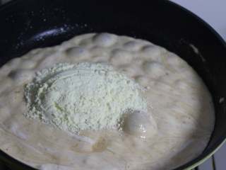 4、雪花酥,倒入奶粉，快速翻拌均匀