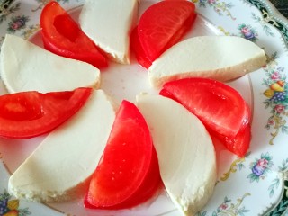 7、家宴颜值凉菜～番茄豆腐花,将豆腐片和西红柿片摆在盘子里