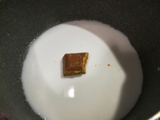 2、椰风咖喱披萨,将椰浆放入奶锅，开小火，放入咖喱块，不断搅拌。