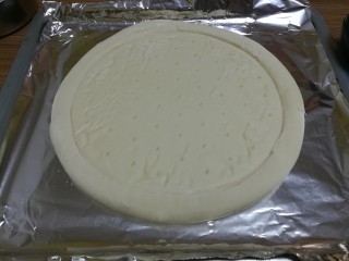 6、椰风咖喱披萨,准备好披萨面饼，放烤盘里先烤180度五分钟取出来。