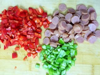 2、吐司披萨盏,青椒，红椒切丁，火腿肠切小圆片。