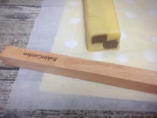 16、双色格子/棋盘饼干,步骤11切去的边料面团颜色分开,擀成薄片,刷上蛋液,把冻好的格子条包裹起来。包好后,切去多余的面片,盖上保鲜膜,冰箱冷冻20分钟,定型