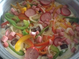 2、多彩铁锅披萨,面粉鸡蛋 加水搅拌均匀。锅底加热倒入橄榄油 铺上搅拌好的面粉 小火。铺上辅料 。