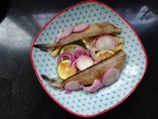 3、柠檬香辣烤冰鱼,冰鱼柳加入洋葱、姜丝，加入生抽、料酒、白糖、盐。挤入半个柠檬的柠檬片汁、挤完汁的柠檬片直接放里面。