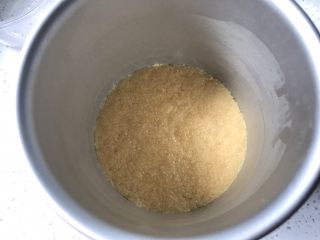 4、夏日芒果慕斯,模具底部铺上油纸，再将拌好的饼干碎铺在模具底部，压平，可以用擀面杖压。弄好以后放入冰箱冷冻20分钟