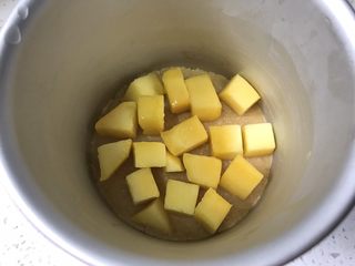 10、夏日芒果慕斯,取出冷冻好的饼干底，放入适量芒果块。