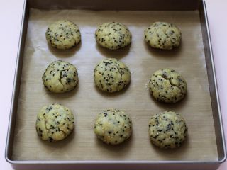 9、酥得掉渣的芝麻桃酥,松弛好的面团，分割成等份的小团，放入垫有油纸的烤盘中。（每个小团约45克）