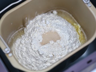 1、芝士肉排汉堡,把汉堡胚所需食材(黄油和芝麻除外)放入面包机内，启动面包机揉面程序开始揉面