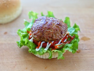 14、芝士肉排汉堡,然后挤上适量的沙拉酱、番茄酱，再放上煎好的肉排