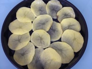 3、火腿芝士烤土豆片,披萨盘涂一层黄油或食用油，将土豆片码放入披萨盘中。