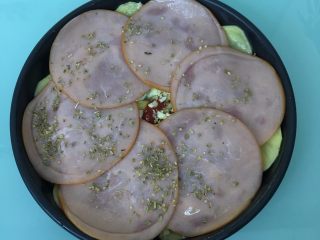 6、火腿芝士烤土豆片,铺上火腿片，撒上少许披萨草。