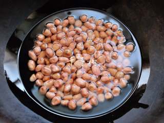 2、香酥油炸花生米,向锅内加适量油，即将没过花生米即可，然后开最小火开始炸。油的用量可以减少，那样就变成了炒花生米，或是焙花生米。