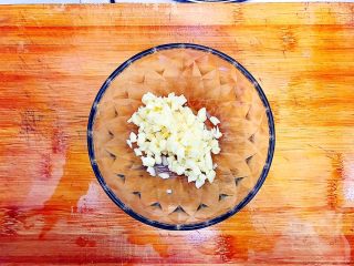 8、金蒜秋葵拌茄子,大蒜去皮洗净之后切碎，不用切的太碎，如图所示，随便切一下就可以了，备用！