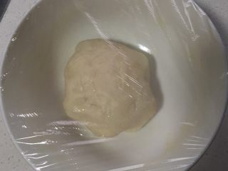 2、火腿鸡肉披萨,加入少许盐、面粉、橄榄油,调成面团,盖上保鲜膜发酵