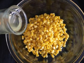 5、玉米烙,刚才煮沸的汤水挖入小半勺，让每粒玉米粒上沾上水