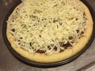 7、自己动手做披萨,如图洒上奶酪,放入烤箱,15-20分钟。