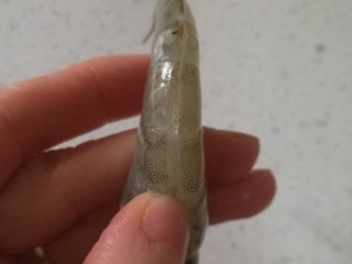 2、烤虾,用剪刀剪开虾尾巴去掉虾线