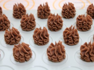 8、好吃到停不下来的珍妮曲奇小花（巧克力篇）,8、烤盘中铺上烤纸，或者使用曲奇烤盘，挤上均匀的小花，注意之间隔开一点。