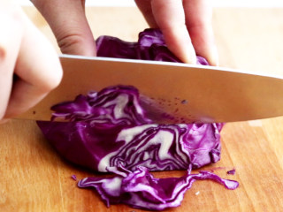 3、紫甘蓝拌木耳,紫甘蓝冲洗干净，然后切成细丝待用。紫甘蓝切丝后，要注意用手将其掰散开，这样甘蓝丝更能入味。