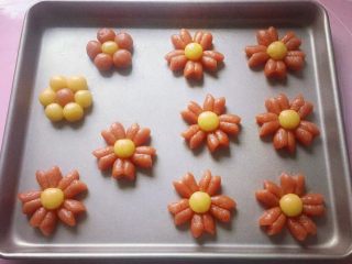 13、吃掉一朵花+小红花饼干,依次做好的小红花摆放在不粘烤盘中，如果不是不粘烤盘，记得要垫一张油纸哦。