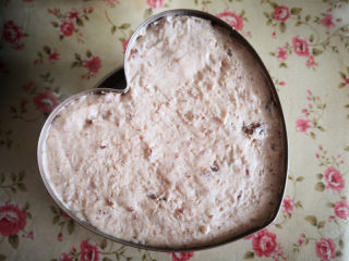 9、樱桃慕斯,再倒入一部分慕斯液，再放入最后一片蛋糕片，然后把其余的慕斯液都倒入模具里，表面抹平，放入冰箱里冷藏大约4个小时，