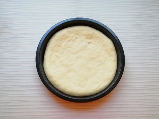 6、火腿彩蔬披萨,发酵好的面团揉光排气，擀成和披萨盘一般大小的面饼，放入披萨盘里。