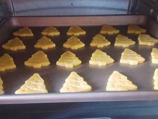 13、圣诞树饼干,将烤盘放入预热好的烤箱中层，上下火150度，烤15分钟，出炉晾凉即可。