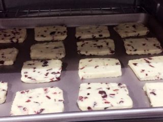 12、蔓越梅饼干,将烤盘放入预热好的烤箱中层，上下火170度，18分钟，待饼干表面变成微黄色即可。