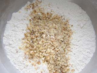 4、看得到核桃仁的核桃酥 香酥可口真材实料超满足,过筛后的粉类加入切碎后的核桃仁，拌匀。