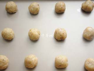 8、看得到核桃仁的核桃酥 香酥可口真材实料超满足,把混合好的桃酥面团等分成12个，搓圆后摆入烤盘，每个小球之间保留足够的空隙。