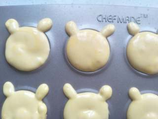 10、小熊蛋圆饼干,再拿一个裱花袋，剪小一点的口，挤上两个小圆形做耳朵。余留的面糊同样操作