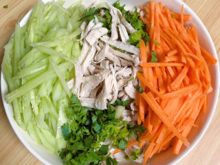 9、手撕鸡胸肉,将鸡肉丝、黄瓜、胡萝卜丝、香菜末都放入大碗中。