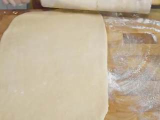 6、肉桂面包卷,把面团按扁，用擀面杖擀成四方形的面片