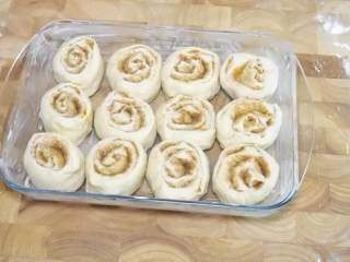 11、肉桂面包卷,把面包卷切面朝上的放入烤盘中，盖上保鲜膜发酵20分钟