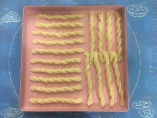 12、马苏里拉奶酪棒,小条面片两头反方向扭转，排在烤盘上，两头稍稍用力在烤盘上压一下，起固定作用