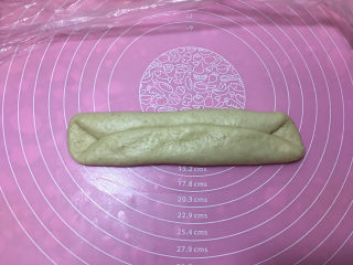 6、燕麦辫子花环汉堡面包,醒发完毕后，取一个面团擀开，翻面过来后横放面团，将上下对折。