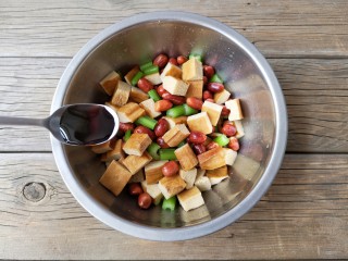 12、花生米拌豆腐干,再加一小勺味极鲜酱油。