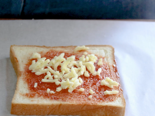 9、吐司培根披萨,吐司涂完番茄酱后,撒层马苏里拉奶酪