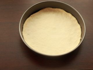 8、萨拉米培根玉米披萨,将面团放入模具中，用手整理成圆