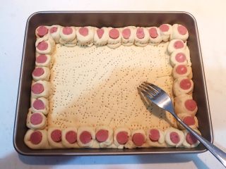 27、香肠苹果披萨,用叉子在面皮底部扎出密集的小孔