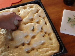 8、 迷迭香佛卡夏,用指头在面团上戳出小洞。