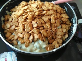 8、网红甜品+ 雪花酥,倒入饼干，拌匀。